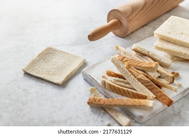 Toast Bread Slice Thinned With Wooden Roller Pin On The Table; Cooking At Home - French Toast Rolls In The Making