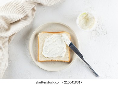 Toast Bread Spread With Cream Cheese In A Plate On A Light Table, Top View.