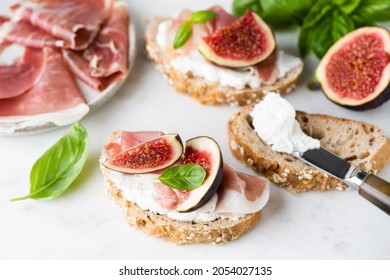 Toast or bruschetta with ricotta cheese, prosciutto and figs on white marble, closeup view - Powered by Shutterstock