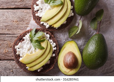 Toast With Cheese, Arugula And Avocado Close-up On The Table. Horizontal View From Above
