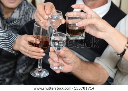 A toast to love,happiness and well-being at the merry feast. People drink wine, whiskey and having fun.