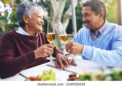 Toast to many more happy years together. Shot of a happy older couple sharing a toast outdoors.