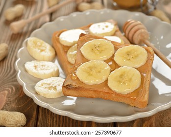 Toast With Peanut Butter And Banana On A Brown Table