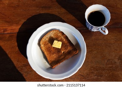 Toasted Bread And Butter With Black Coffee. Overhead Shot Of A Breakfast With Beautiful Morning Sunlight.