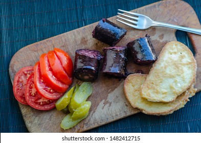 Toasted Bread, Pieces Of Black Pudding, Sliced Vegetables And A Fork On A Wooden Board. Delicious Nutritious Breakfast. View From Above. Horizontally