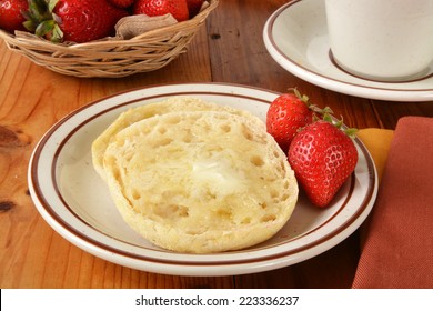 A Toasted And Buttered English Muffin With Fresh Strawberries