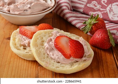 A Toasted English Muffin With Cream Cheese And Fresh Strawberry Slices