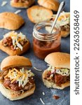 Toasted pulled pork sliders served with homemade tangy barbecue sauce.