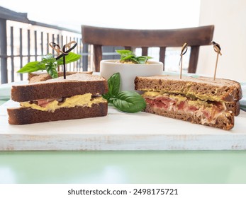 Toasted rye bread sandwich with sliced Italian ham and creamy homemade avocado cashew spread on white wooden board. Light summer easy recipe lunch - Powered by Shutterstock