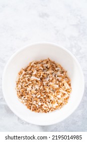 Toasted Shredded Coconut Flakes In A White Ceramic Bowl.