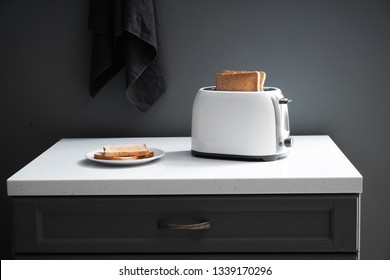 Toaster With Bread Slices On Kitchen Table