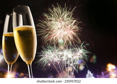 Toasting With Champagne Glasses Against Fireworks 