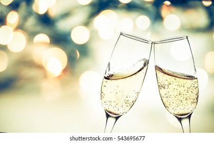 Toasting With Champagne Glasses Against Holiday Lights And New Year Fireworks