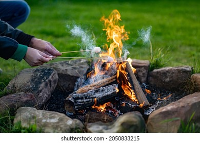 Toasting A Marshmallow On An Open Camp Fire Pit