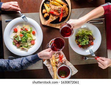 Toasting with red wine, Young happy amorous couple with glasses of redwine on romantic date at restaurant. Top view, flat lay