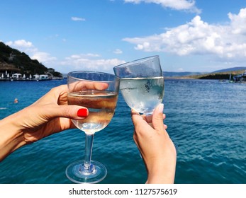 Toasting Wine Glasses Against Sea And Sky In Summer