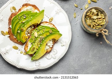 Toasts For Breakfast Or Lunch With Avocado Rye Bread, Sliced Avocado, Pumpkin Seeds. Vegetarian Sandwiches. Healthy, Clean Eating Concept. Vegan Or Gluten Free Diet. Top View.