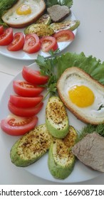 Toasts With Fried Egg And Zucchini Grilled With Fresh Tomatoes On A Plate.