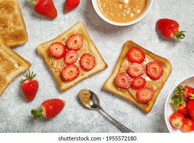 toasts with peanut butter and fresh strawberries on a gray background. view from above - Shutterstock ID 1955572180