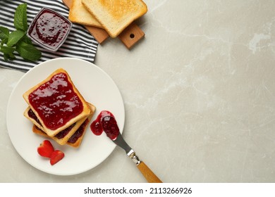 Tostadas servidas con mermelada deliciosa, menta y fresa sobre mesa de mármol claro, puesta plana. Espacio para texto