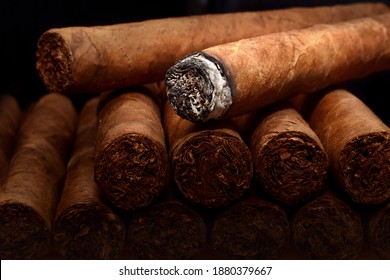 Tobacco cuban havana cigars romeo and julia burned with ash. Beautiful macro background in low key.