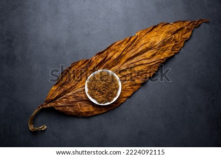 Tobacco leaves and cut tobacco on black background