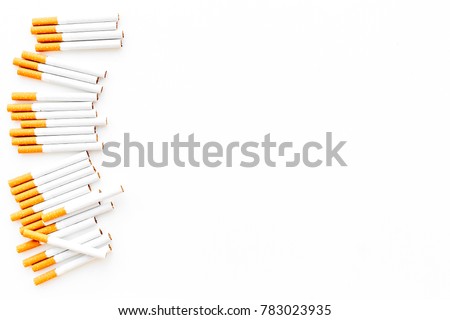 Tobacco. Row of cigarettes on white background top view copyspace