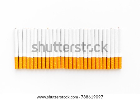 Tobacco. Row of cigarettes on white background top view