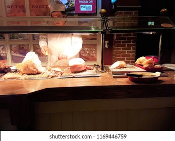 Toby Carvery, Banbury, Oxfordshire, UK 31.08.2018 - Chef carving meat and serving behind counter at carvery