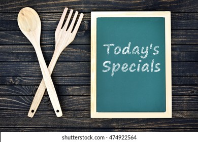 Today's Specials Text On Green Board With Fork And Spoon On Wooden Table