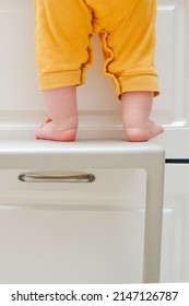 Toddler Baby Boy Climbed With His Feet On A High Chair To Climb On The Kitchen Cabinet. Child Safety Issues In The Home Room, Little Kid