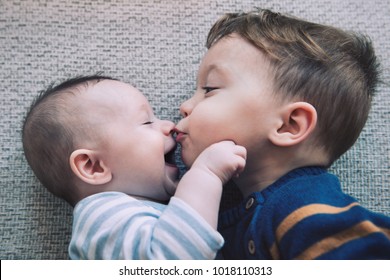 Toddler Baby Boy Kisses His Happy Brother