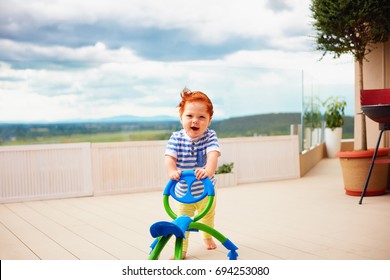 A Toddler Baby Boy Pushing Pushing Go Cart, Outdoors