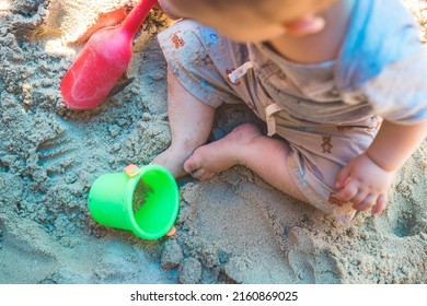 Toddler Baby Playing Concept: Young Boy Playing In The Sandbox, Summer Time