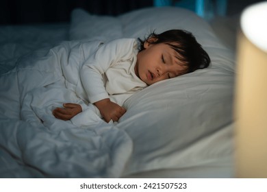 toddler baby sleeping on a bed at night - Powered by Shutterstock