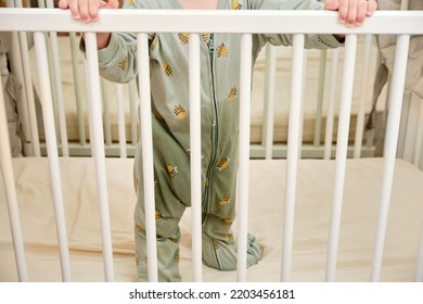 Toddler Baby With Wet Pants Due To A Leaking Diaper Stands In A Crib After A Night Sleep