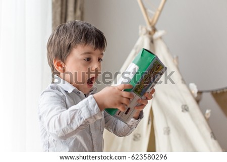 Toddler boy (3 year old) looking at a toy box