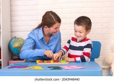 Toddler boy in child occupational therapy session doing sensory playful exercises with her therapist. - Shutterstock ID 2043948440