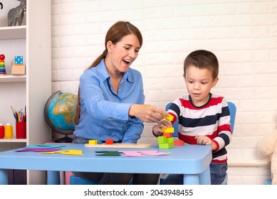 Toddler boy in child occupational therapy session doing sensory playful exercises with her therapist. - Shutterstock ID 2043948455