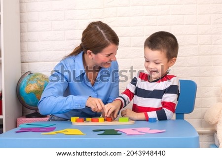 Toddler boy in child occupational therapy session doing sensory playful exercises with her therapist. Stock foto © 
