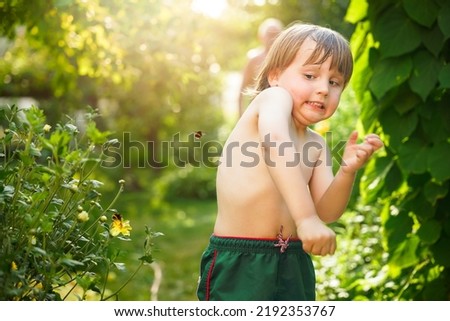 Toddler boy dodging flying bumblebee in summer. Emotional child affraid of bees. Insect phobia