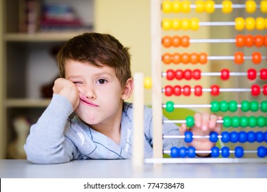 Toddler boy feeling bored and tired while playing with abacus at kindergarten. Hyperactive kid having attention deficit disorder - Shutterstock ID 774738478
