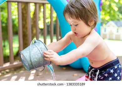 Toddler Boy Playing Buckets Of Water Outside