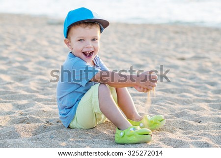 Toddler boy playing on the beach in summer