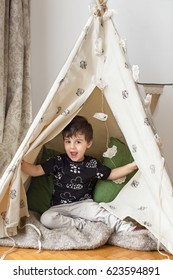 Toddler boy playing in a teepee