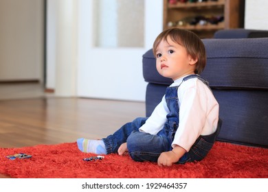 Toddler Boy Playing With Toy Car Alone In Living Room Home. Mixed Race Asian-German Infant.