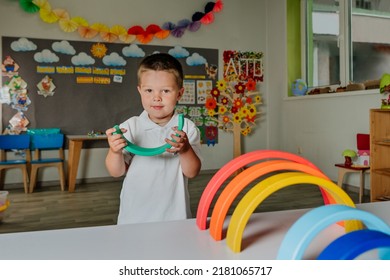 Toddler boy playing with wooden rainbow in kindergarten. Educational natural building blocks for kids. - Powered by Shutterstock