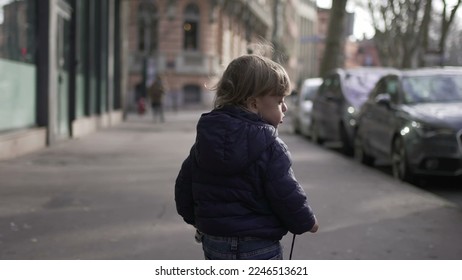 Toddler boy running outside in city during winter, back of child urban sidewalk2 - Powered by Shutterstock