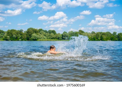 Toddler Boy Swimming And Splashing In River. Summer Activity.