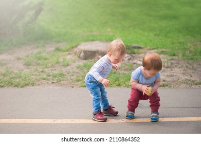 Toddler boys walk and play outside in spring.. - Shutterstock ID 2110864352